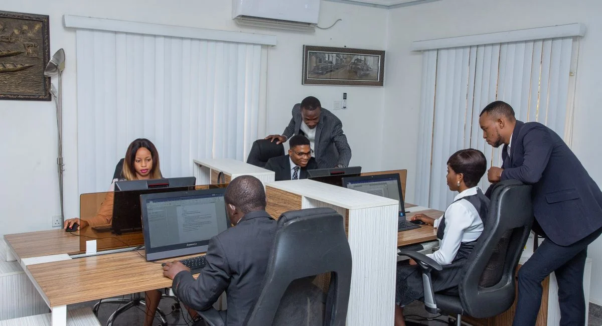 A group of professionals working together in a modern office setting, emphasizing teamwork and productivity.