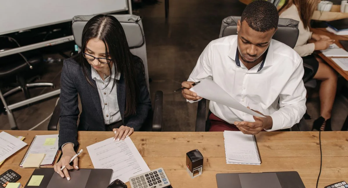 Multiracial office team working on financial documents, highlighting teamwork and productivity.