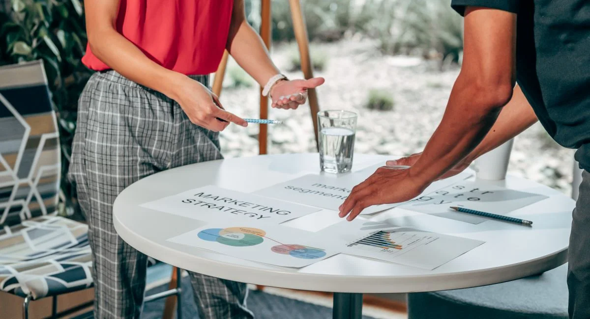Two colleagues collaborate on marketing strategies at a modern workspace.