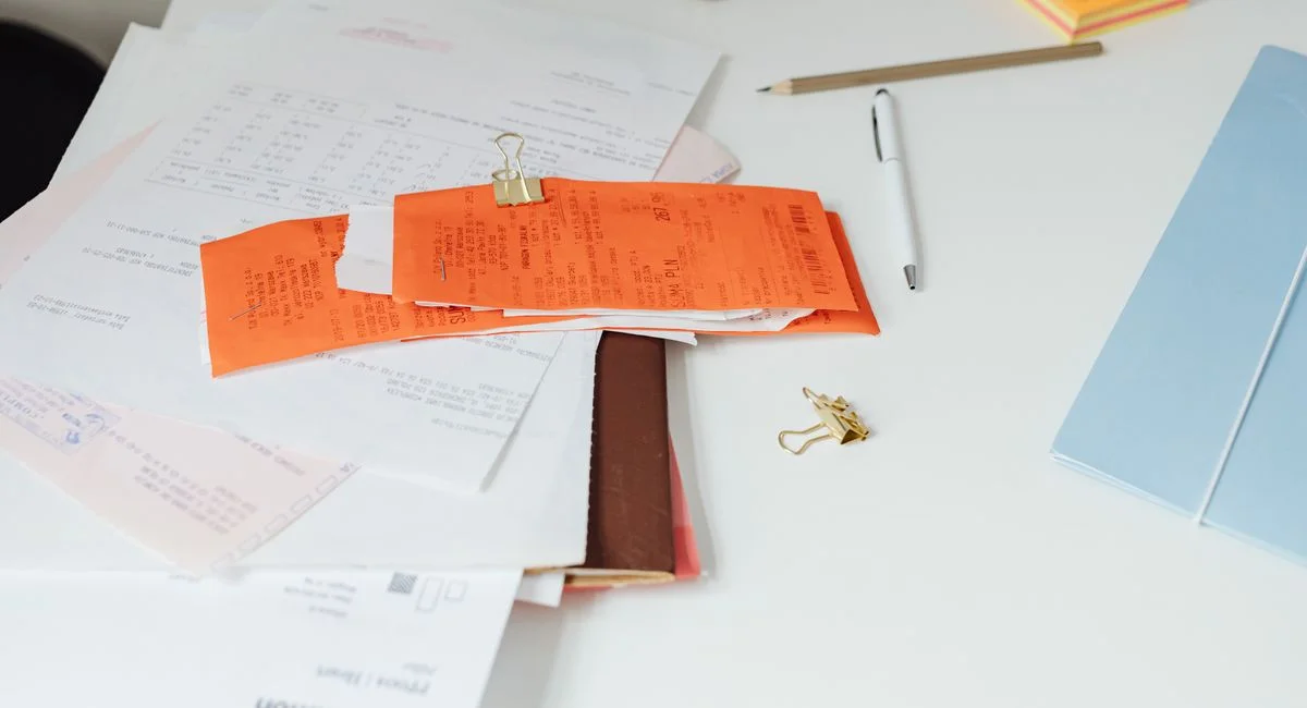 Close-up of a tidy desk with receipts, documents, and office stationery for business organization.