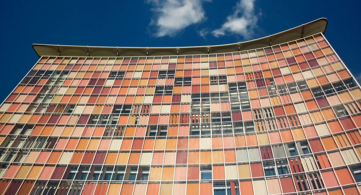 Low-angle shot of a colorful modern building facade in Berlin against a clear blue sky.